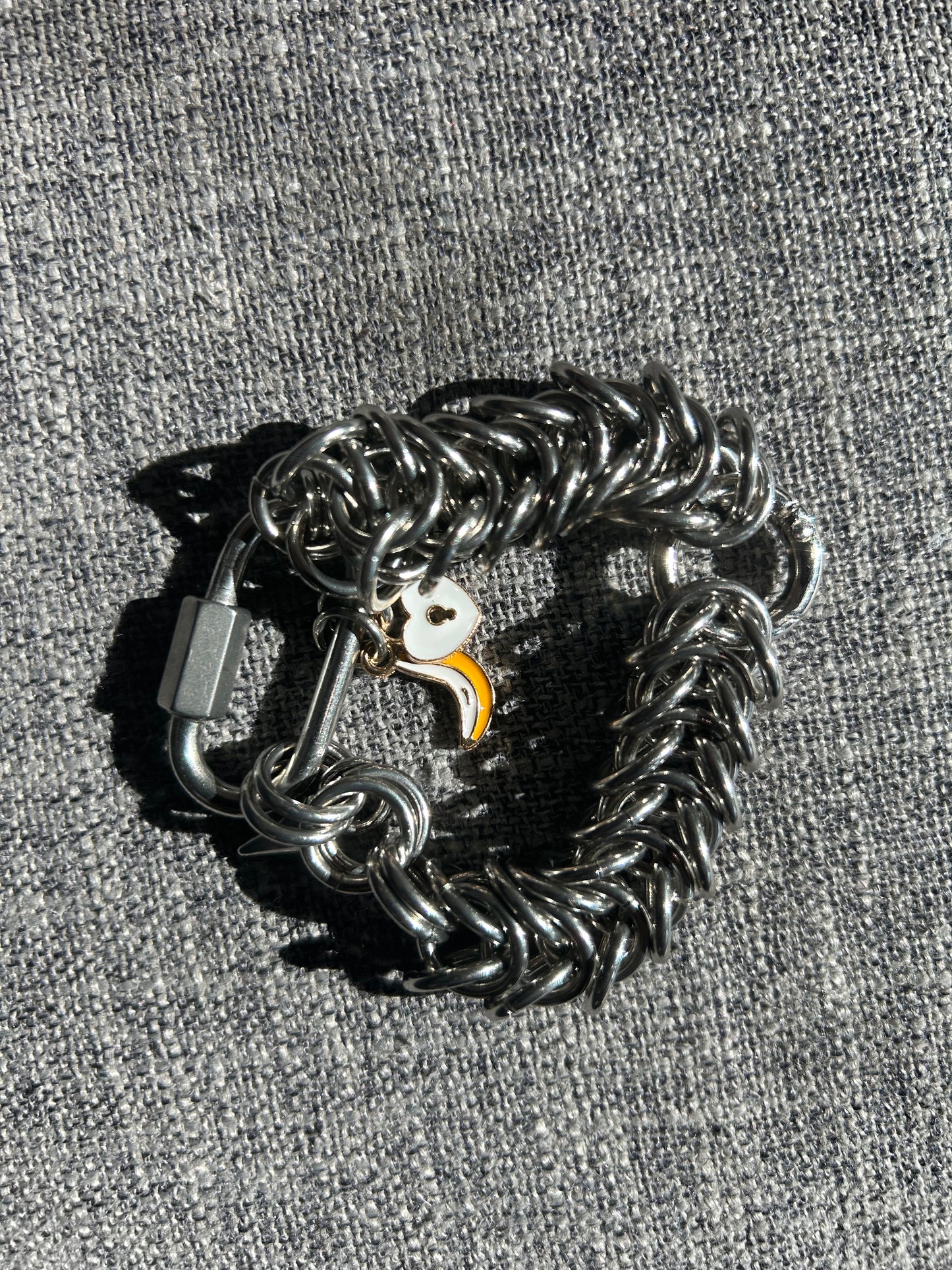 Chain-linked bracelet with banana and heart lock charm