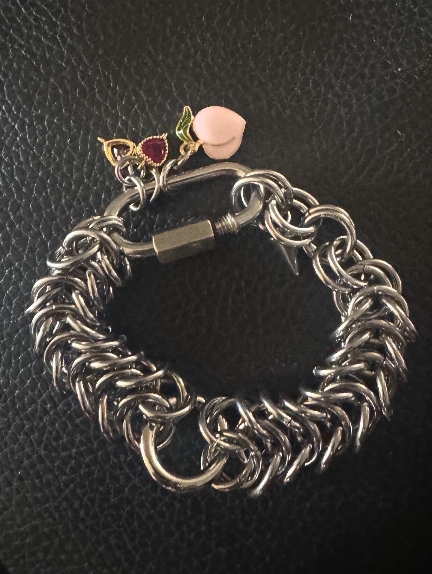 Chain-linked bracelet with purple and burgundy hearts and peach charms