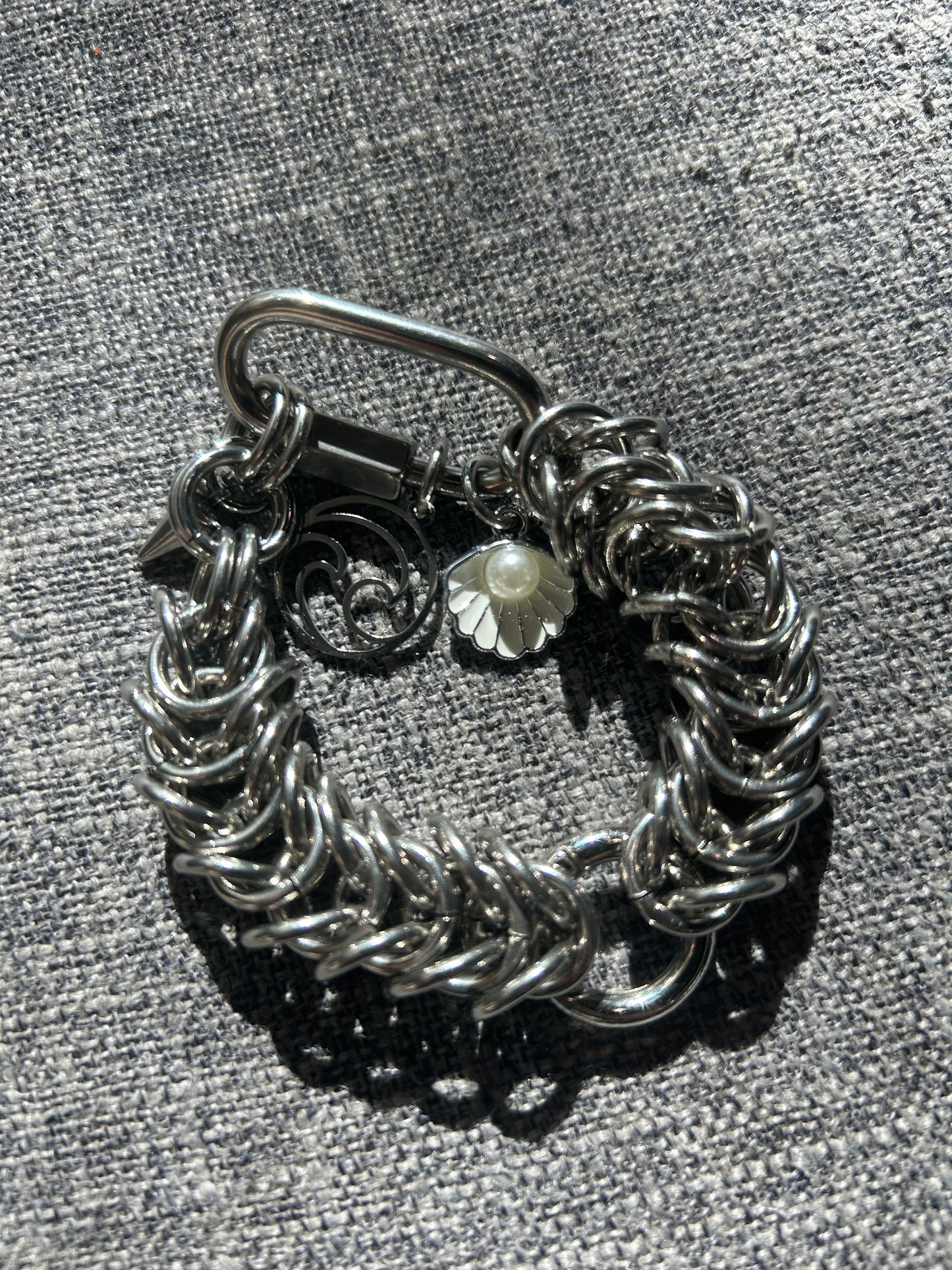 Chain-linked bracelet with wave and pearl charms