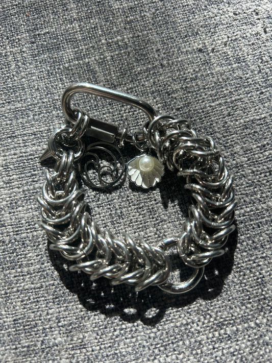 Chain-linked bracelet with wave and pearl charms